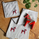 Grytlapp med broderad dalahäst i återvunnet material